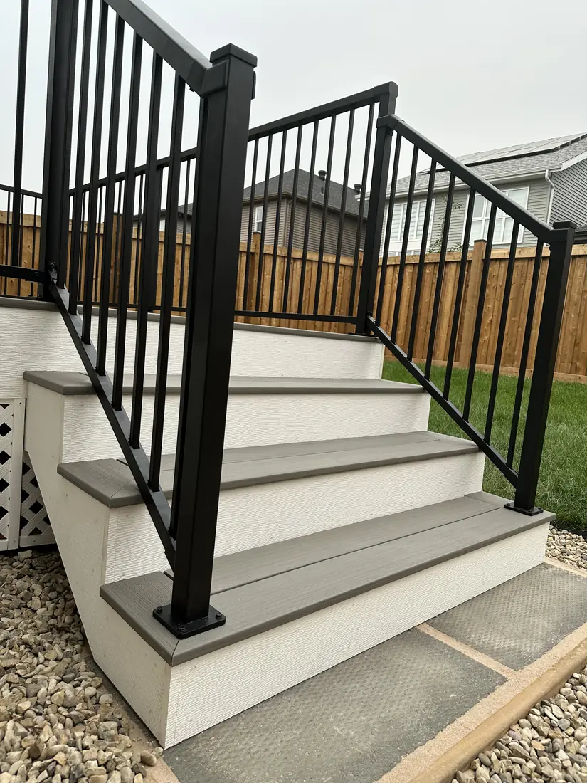Black aluminum picket deck railing and composite stair treads, Edmonton — TrueBlue Builders